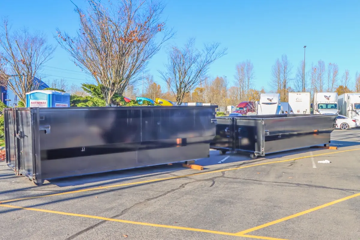 Professional dumpster rental service with roll-off container on residential driveway in Brownfield